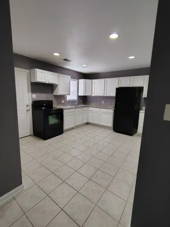 a large kitchen with a large counter top stainless steel appliances and cabinets