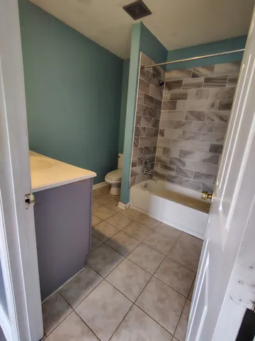 a view of a hallway with wooden floor and a living room