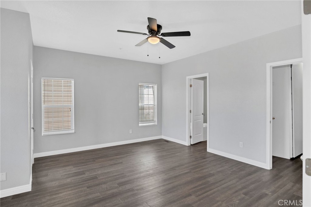 35380 Cheseboro Road Palmdale, CA 93552 - Photo 11 of 42 an empty room with wooden floor chandelier fan and windows