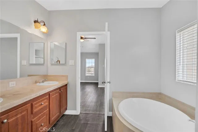a bathroom with a granite countertop tub sink and mirror