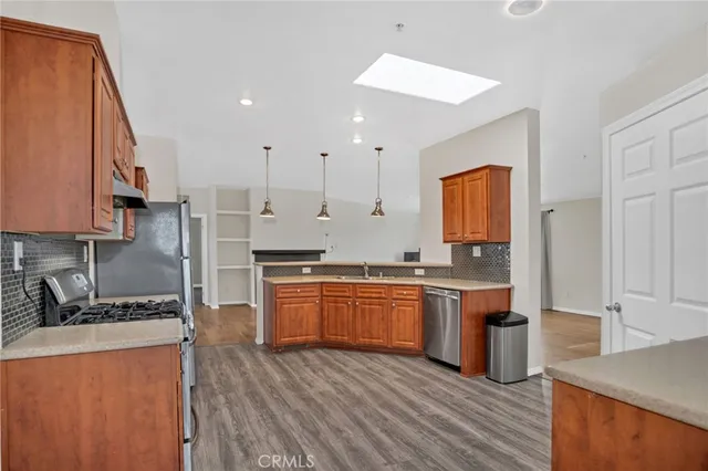 a large kitchen with stainless steel appliances granite countertop a stove a sink dishwasher and a refrigerator