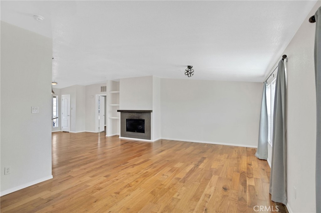35380 Cheseboro Road Palmdale, CA 93552 - Photo 9 of 42 a view of empty room with wooden floor and fireplace