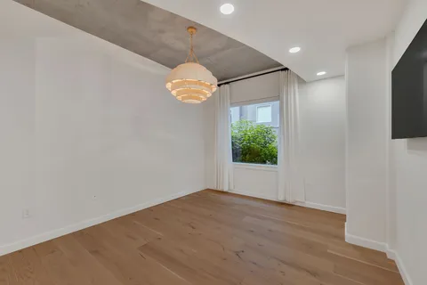 a bedroom with bed tv and a window