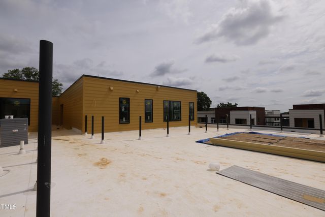 a view of a porch with wooden floor and a bench
