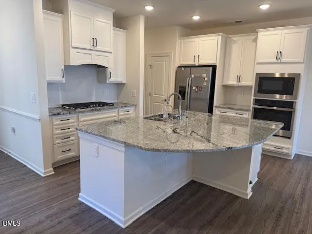 a kitchen with stainless steel appliances granite countertop a stove a sink and a refrigerator