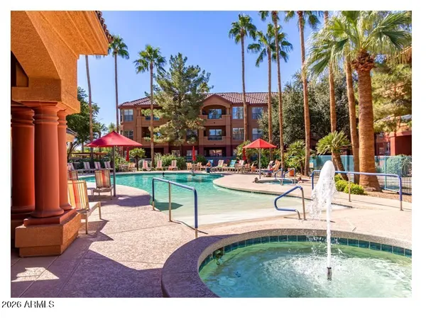 a view of a swimming pool with a bench and tables in the patio