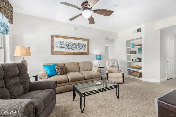 a living room with furniture a chandelier and a flat screen tv