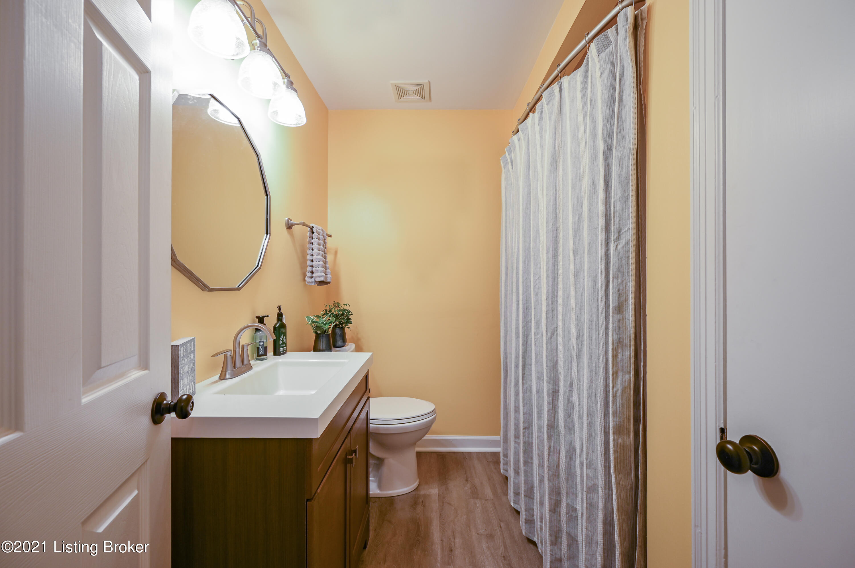 213 Don Allen Road Louisville, KY 40207 - Photo 19 of 53 This bathroom features a gorgeous wooden vanity, a large mirror, sconce lighting, and a shower/tub combo