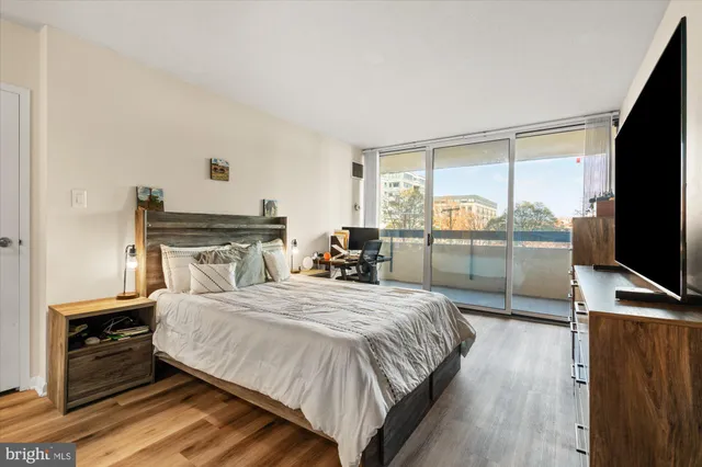 a bedroom with a bed and large windows