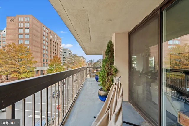 a view of a balcony with a potted plant and outdoor seating