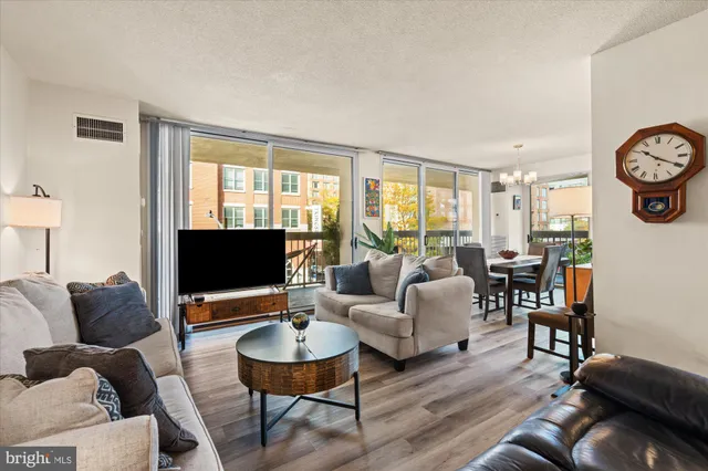 a living room with furniture a flat screen tv and a window