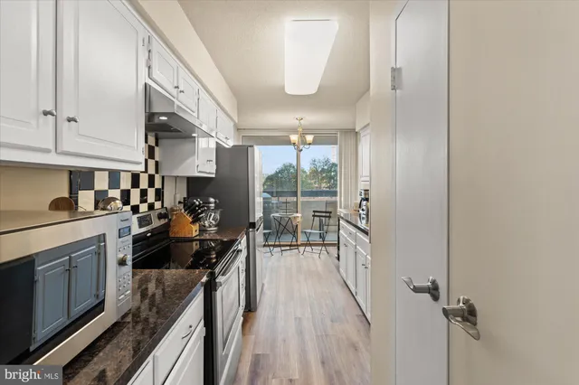 a kitchen with a large window appliances and cabinets