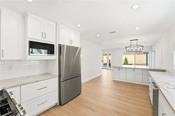 a large kitchen with a lot of counter space and wooden floor