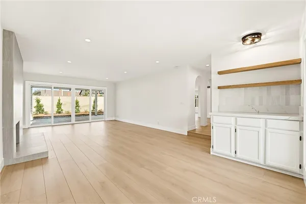a view of a hallway to a bedroom with wooden floor and windows