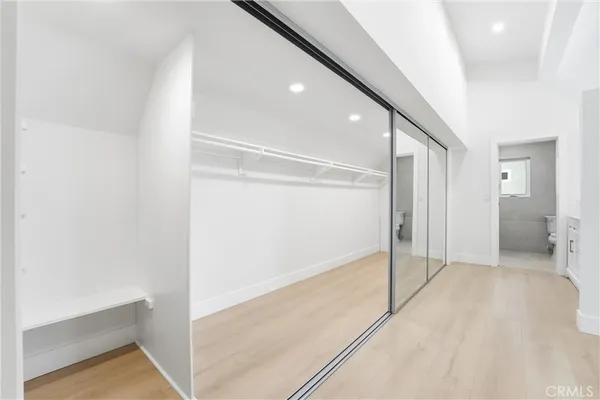 an empty room with wooden floor ceiling fan and windows