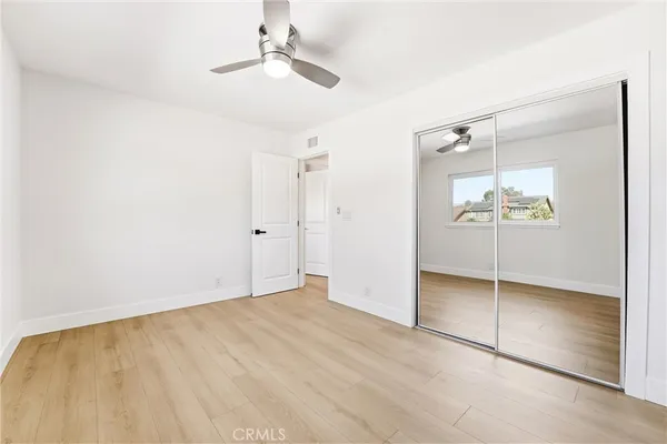 an empty room with a window and ceiling fan