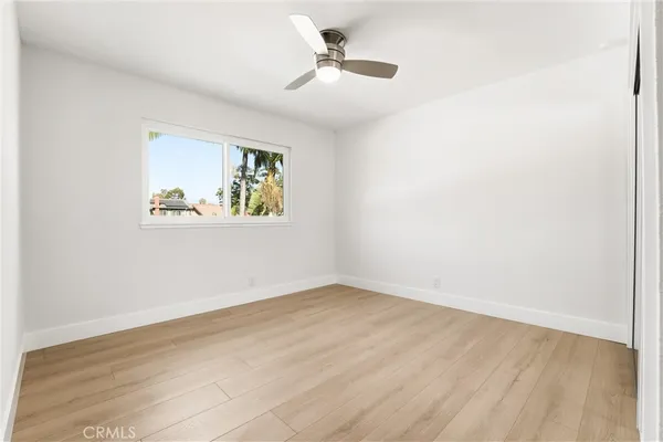 an empty room with a ceiling fan and windows