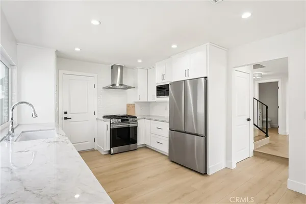 a kitchen with granite countertop white cabinets and stainless steel appliances