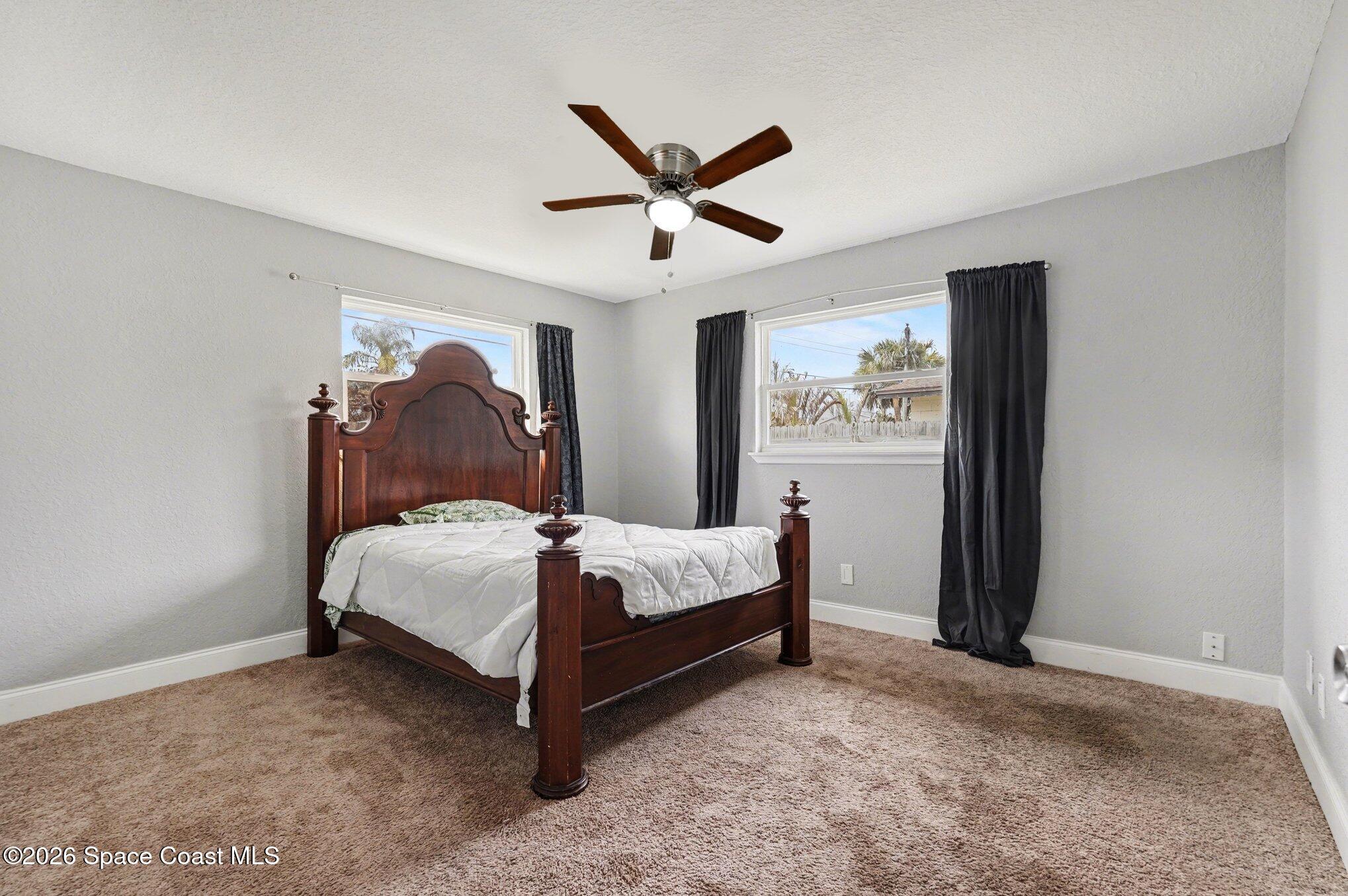 455 Riverside Avenue Merritt Island, FL 32953 - Photo 11 of 28 a bed room with a bed and a ceiling fan