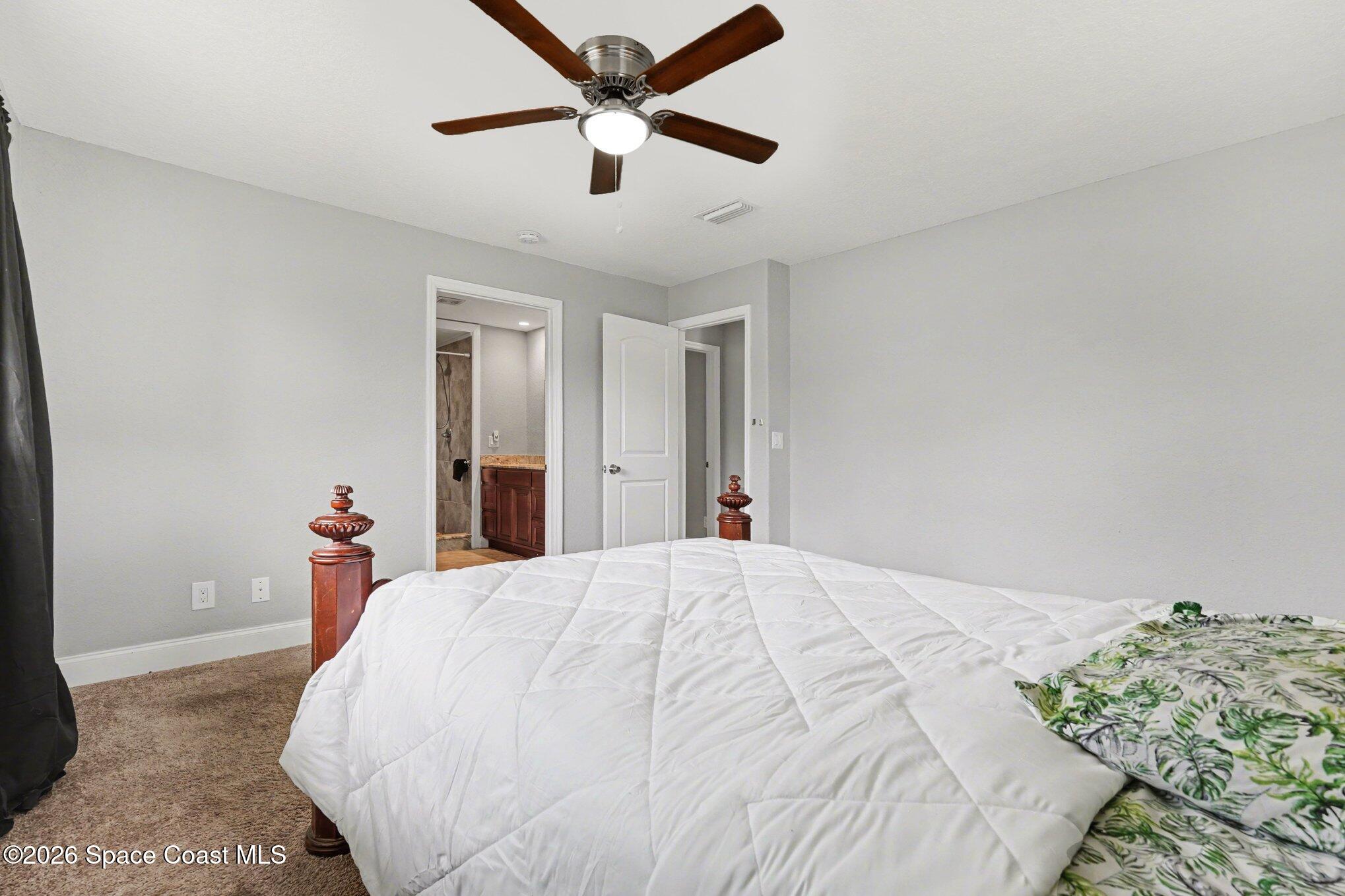 455 Riverside Avenue Merritt Island, FL 32953 - Photo 14 of 28 a bedroom with a bed and a painting on the wall