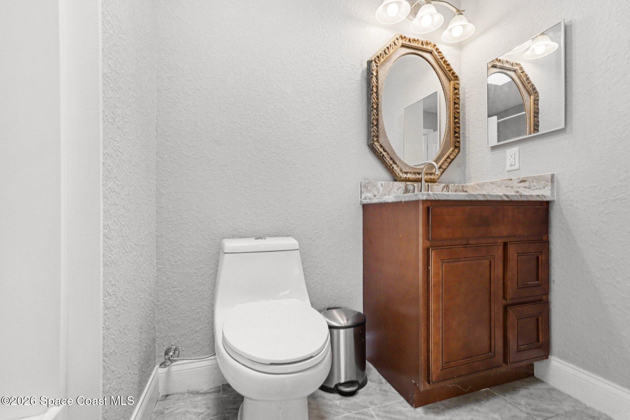 455 Riverside Avenue Merritt Island, FL 32953 - Photo 19 of 28 a bathroom with a toilet and a mirror