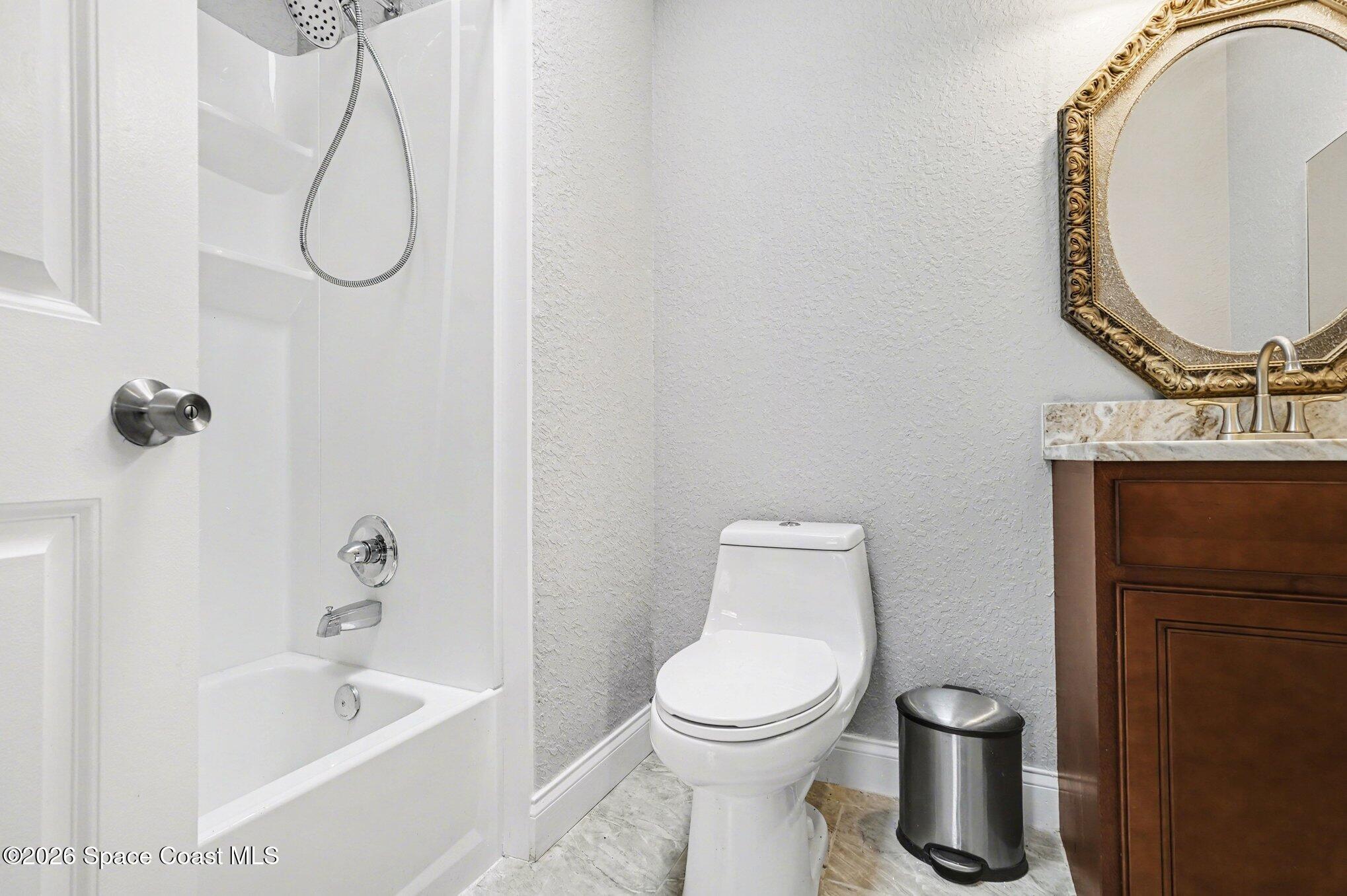 455 Riverside Avenue Merritt Island, FL 32953 - Photo 20 of 28 a bathroom with a toilet sink vanity tub and mirror