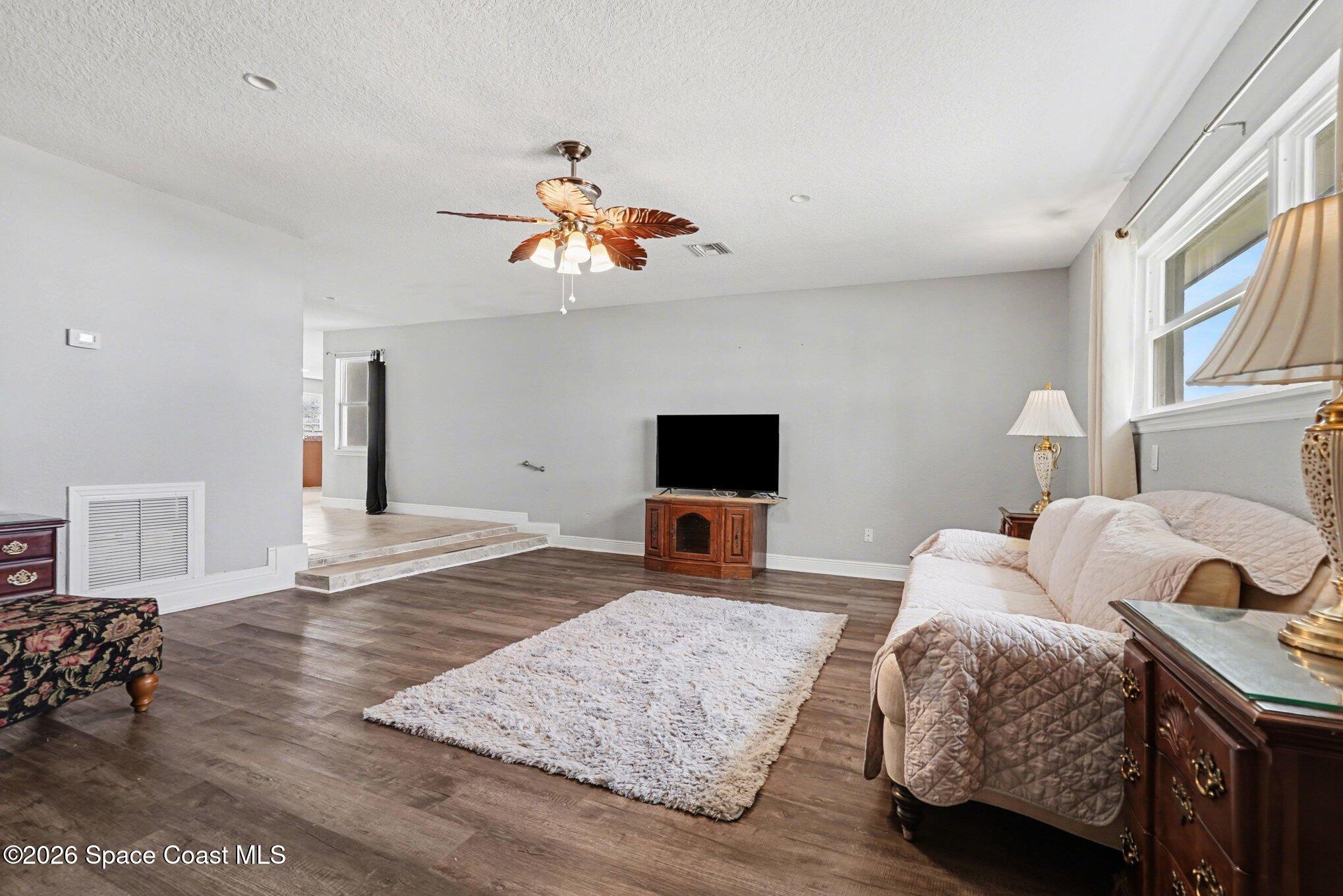 455 Riverside Avenue Merritt Island, FL 32953 - Photo 9 of 28 a bedroom with a bed and wooden floor