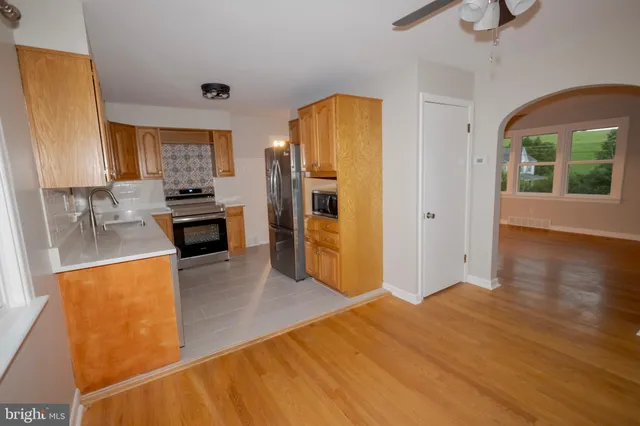 a kitchen with stainless steel appliances granite countertop a refrigerator a stove top oven a sink and dishwasher