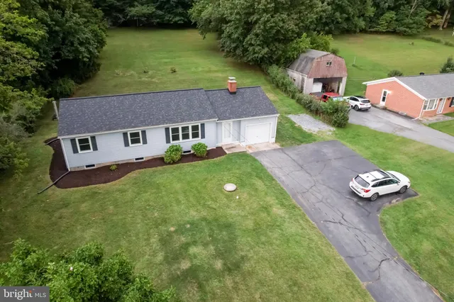 an aerial view of a house with a yard basket ball court and outdoor seating