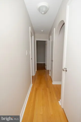 a view of a hallway with wooden floor and entryway