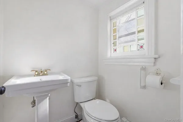 a bathroom with a sink a toilet and a window