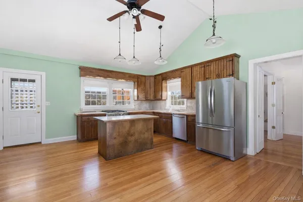 a kitchen with stainless steel appliances granite countertop a refrigerator a sink dishwasher a stove and a refrigerator