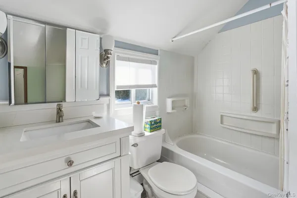 a bathroom with a granite countertop toilet a sink and a bathtub