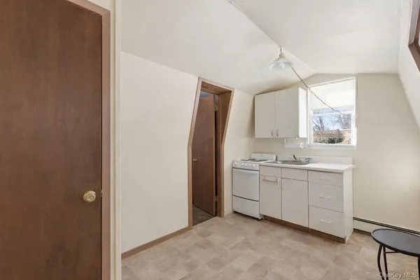 a room with a sink cabinets and a window
