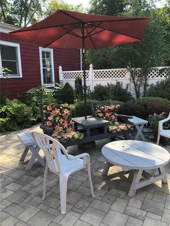 a view of a chairs and table in backyard of a house
