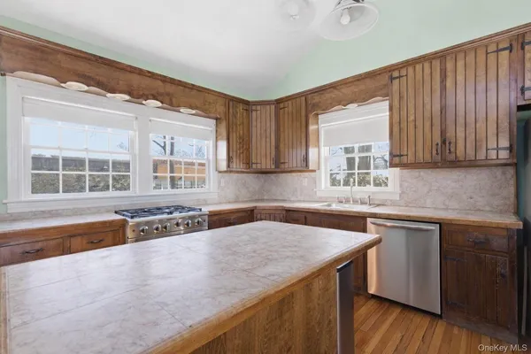 a kitchen with stainless steel appliances granite countertop a sink and a granite counter tops with wooden floors