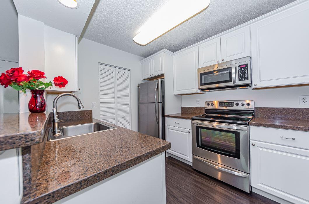 a kitchen with stainless steel appliances granite countertop a sink dishwasher a microwave oven and refrigerator