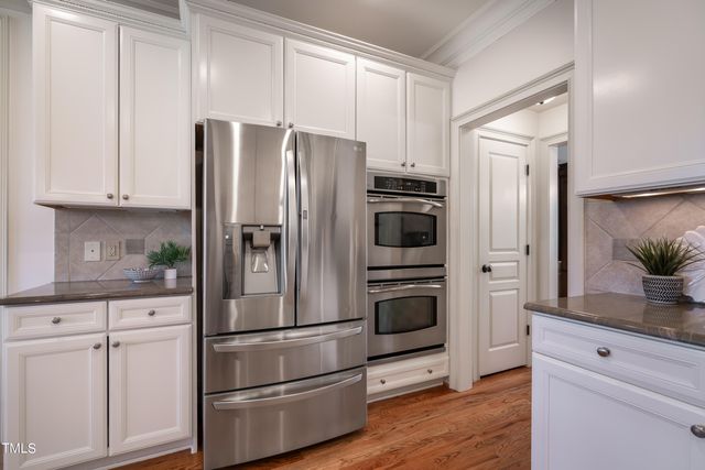 a kitchen with stainless steel appliances a refrigerator stove and cabinets