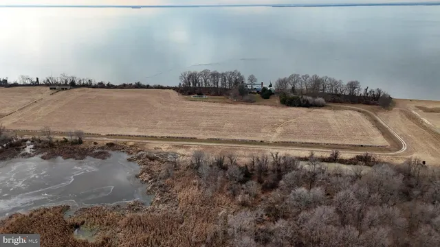 a view of dirt field with wooden fence
