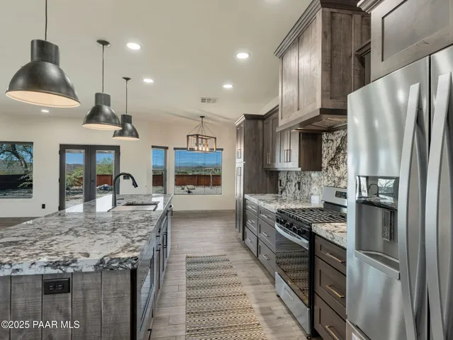 a kitchen with stainless steel appliances granite countertop a stove and a sink