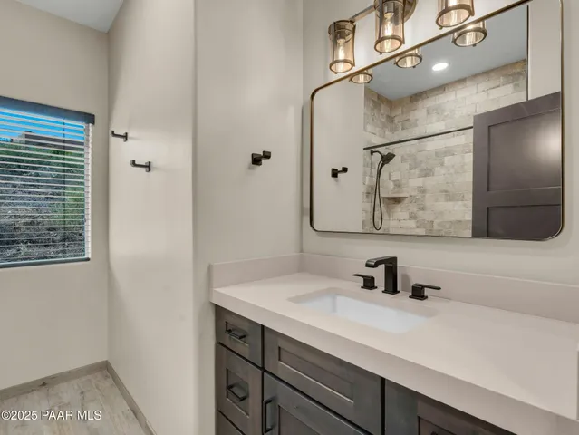 an empty room with wooden floor cabinet and windows