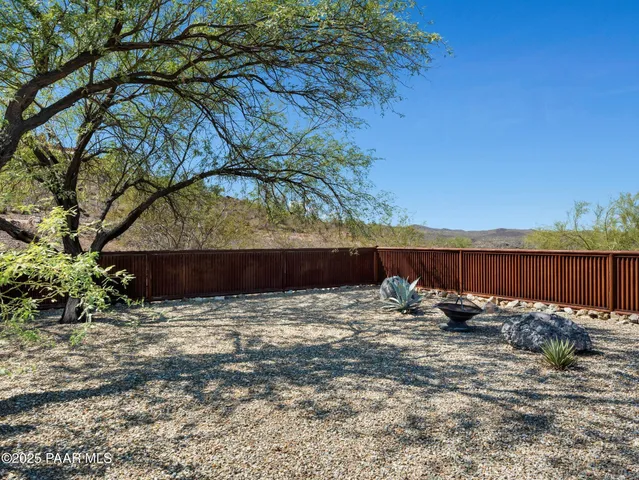 a view of a backyard space with wooden fence