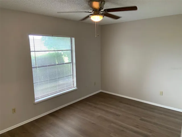 an empty room with a window and wooden floor