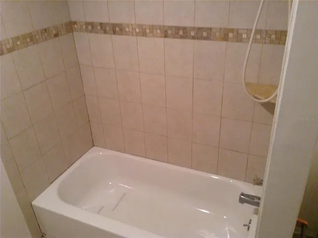 a bathroom with a white bath tub and shower