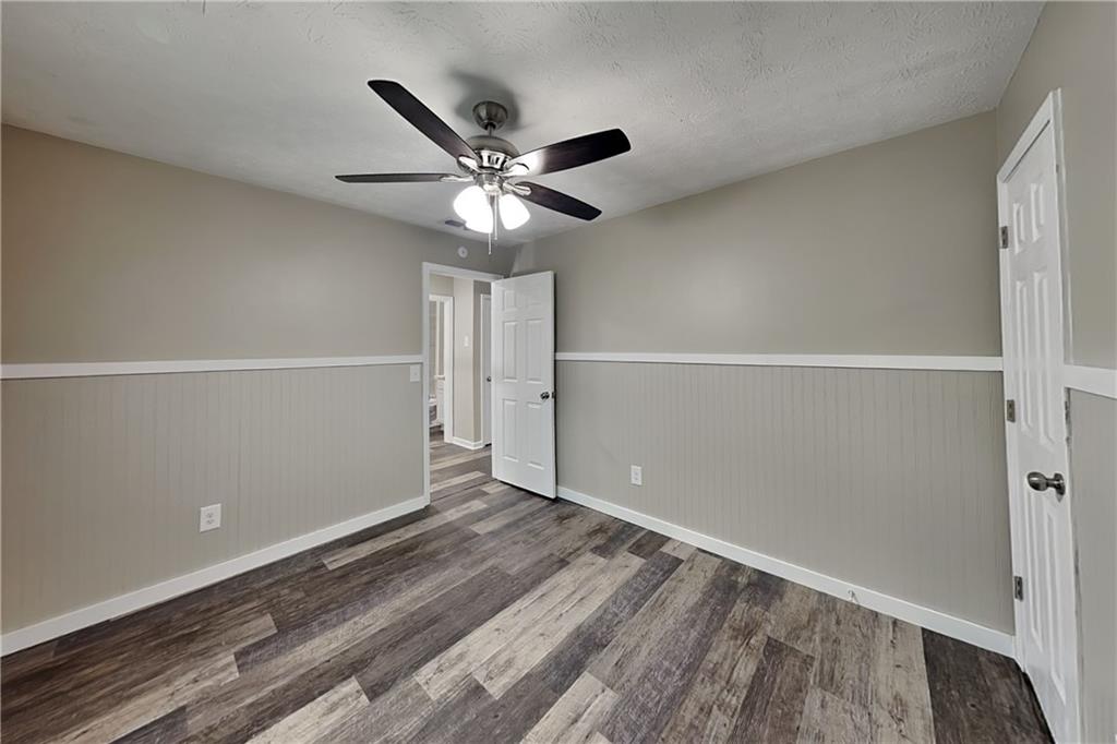 6072 Devonshire Drive Flowery Branch, GA 30542 - Photo 14 of 22 an empty room with wooden floor fan and windows