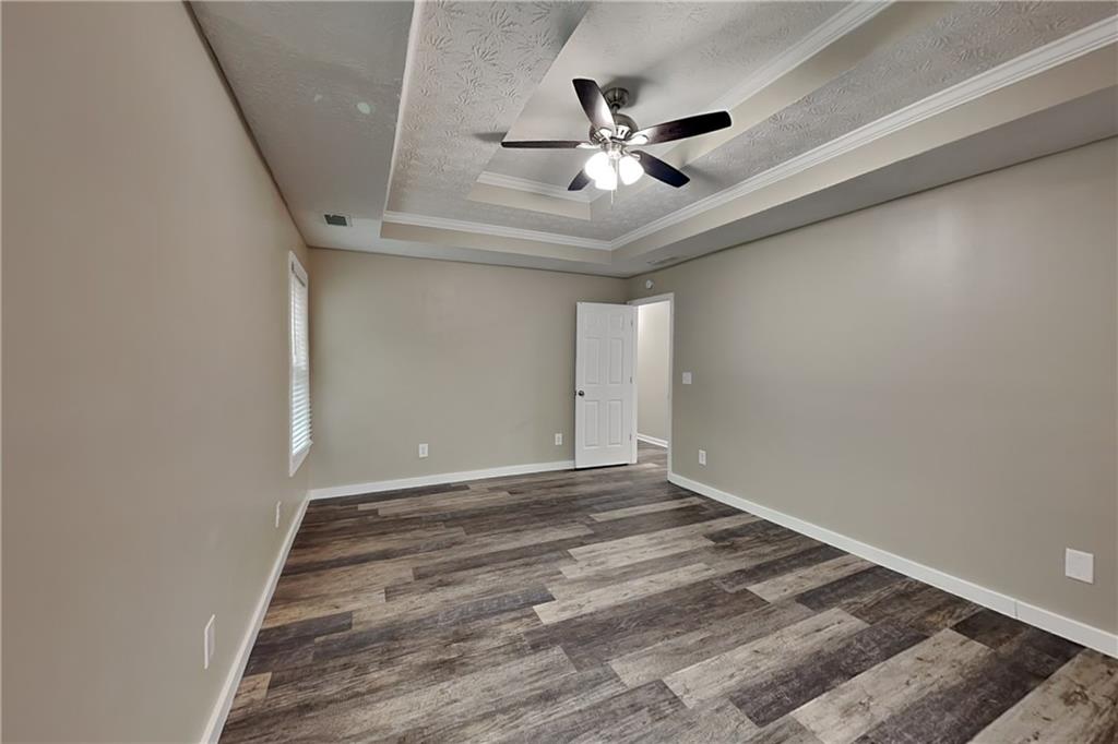6072 Devonshire Drive Flowery Branch, GA 30542 - Photo 17 of 22 a view of an empty room with wooden floor and a ceiling fan