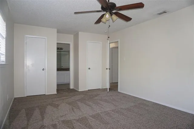 an empty room with closet and a chandelier fan