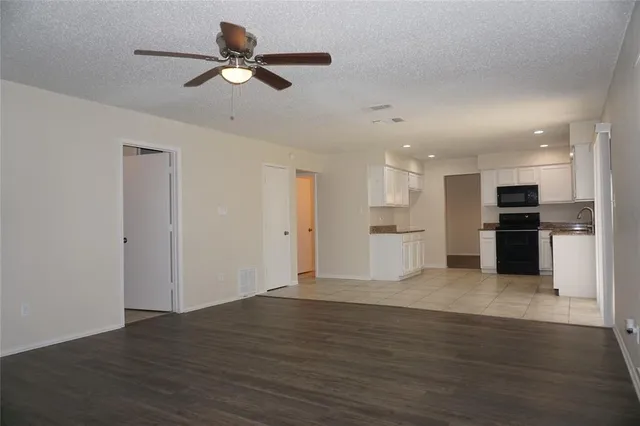 a view of kitchen with wooden floor and a ceiling fan