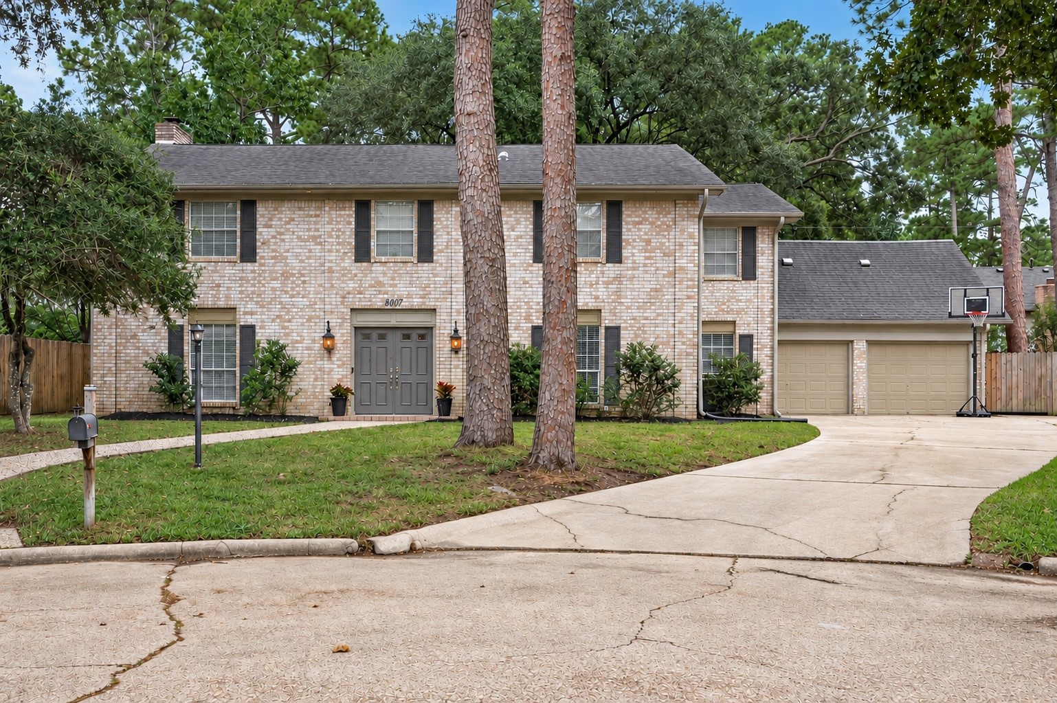A welcoming first impression! Classic brick, mature trees, established landscaping, and a spacious driveway create inviting curb appeal from the moment you arrive