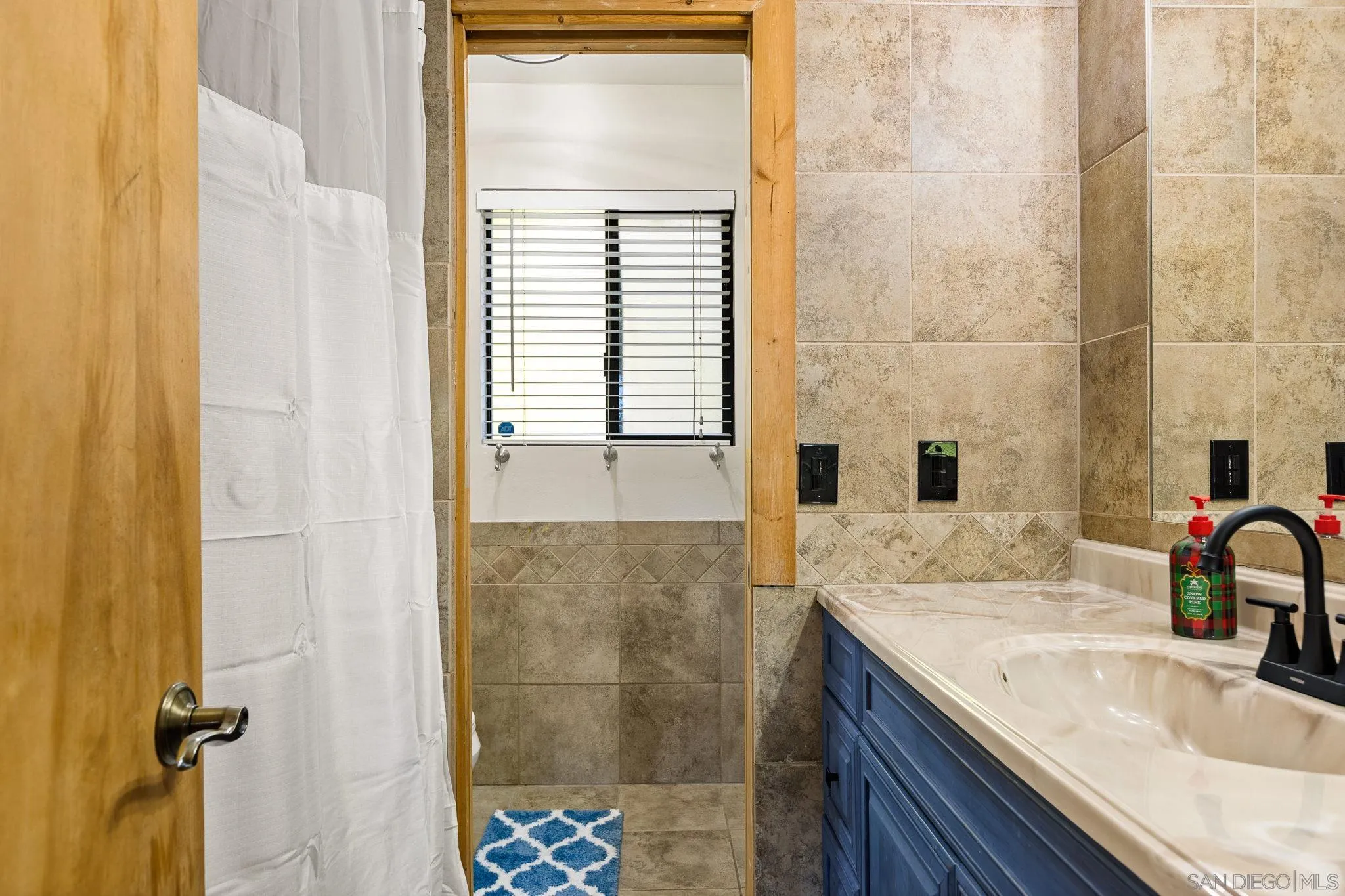683 Grass Valley Road Lake Arrowhead, CA 92352 - Photo 28 of 39 a bathroom with a granite countertop sink a toilet and shower